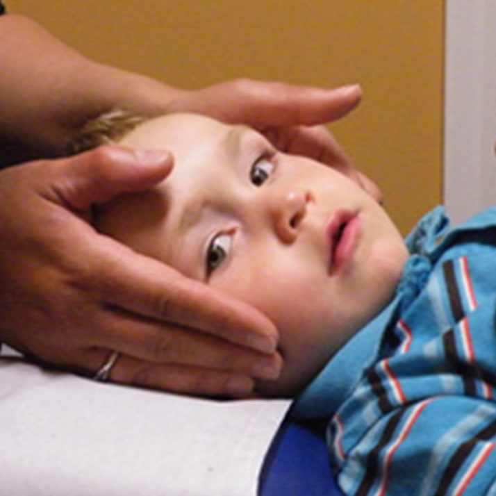 Séance de chiropratique pédiatrique avec un jeune enfant allongé sur la table de traitement